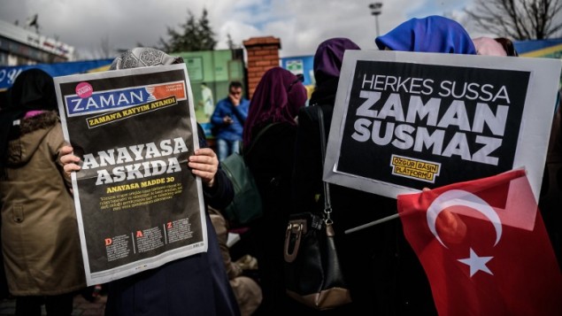 A Zaman supporter reads the latest edition of the Turkish daily newspaper in front of the newspaper's headquarters in Istanbul 