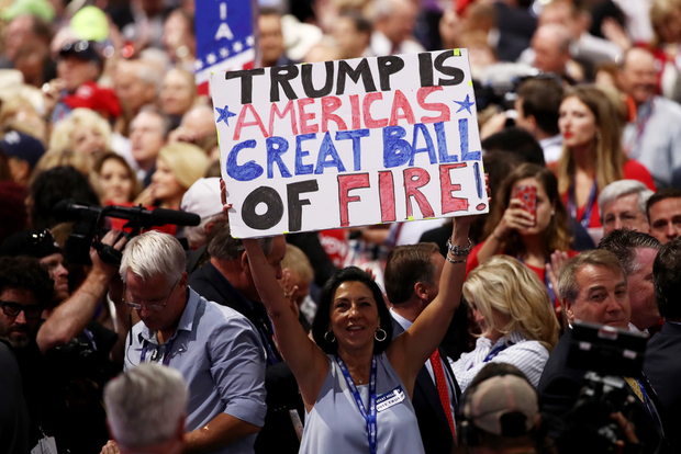 A delegate holds up a sign that reads "Trump is Americas Great Ball of Fire" during the fourth day of the Republican National Convention on 21 July 2016