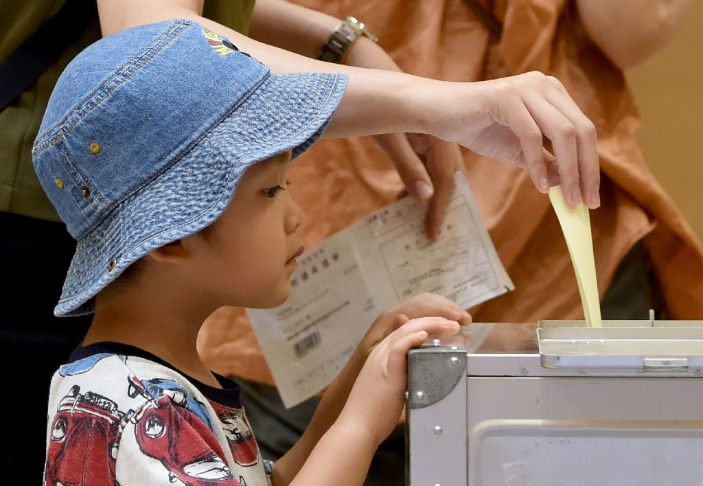  A boy watches as his mother casts her ballot at a polling station in Tokyo A boy watches as his mother casts her ballot at a polling station in Tokyo (AFP Photo/Toru Yamanaka) 