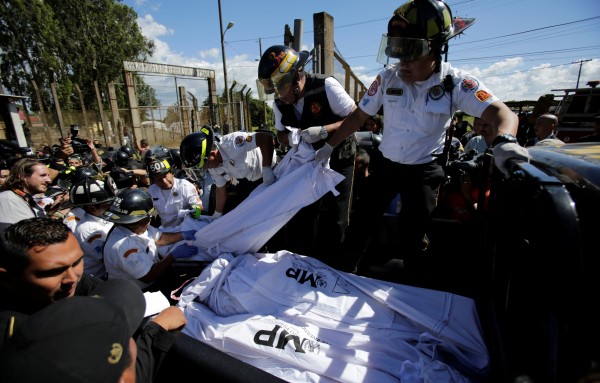 Firefighters remove bodies from the Pavon prison following a riot that killed former army captain Byron Lima
