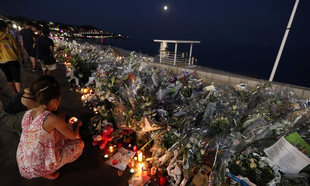 People light candles at a makeshift memorial on the Promenade des Anglais in Nice