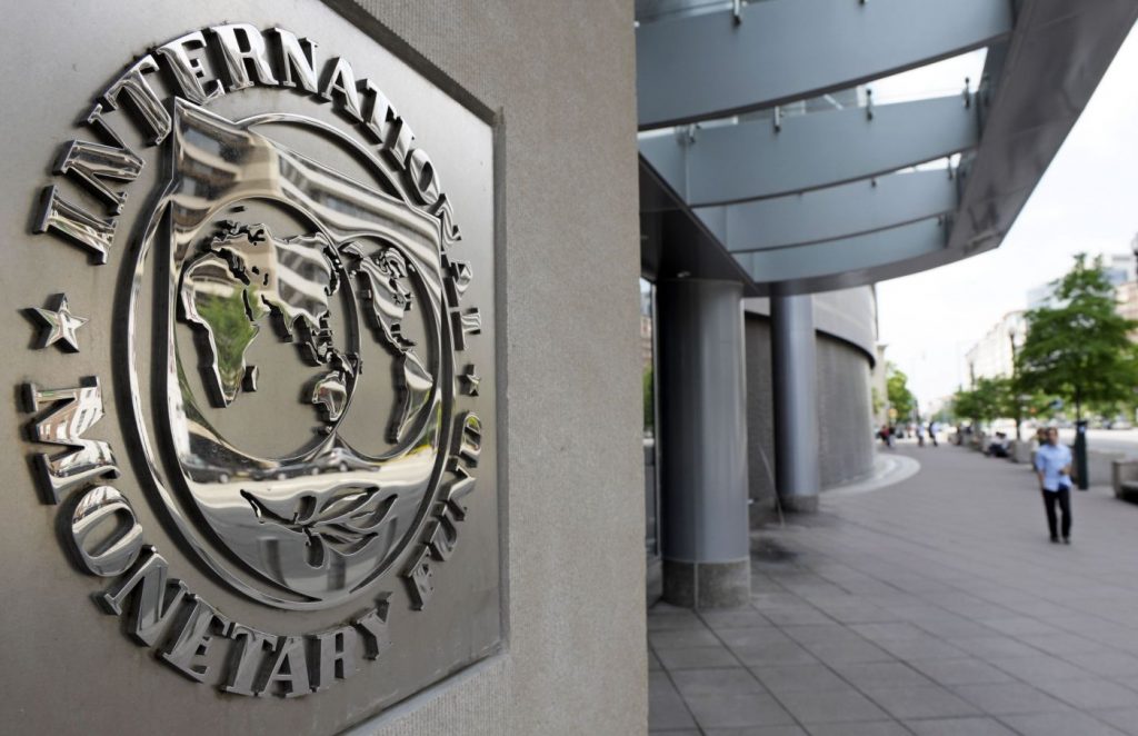 Pedestrians walk past the International Monetary Fund headquarters' complex in Washington
