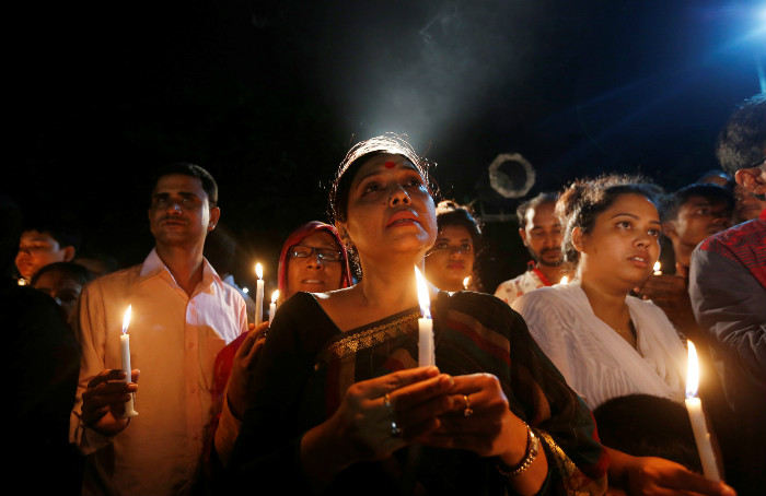 People attend a candlelight vigil for victims of the Dhaka attack in Bangladesh's capital