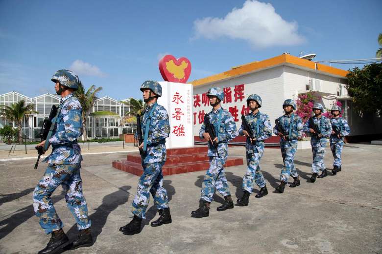 Soldiers of China's People's Liberation Army Navy patrol at Fiery Cross Reef, in the Spratly Islands, known in China as the Nansha Islands * PHOTO: REUTERS