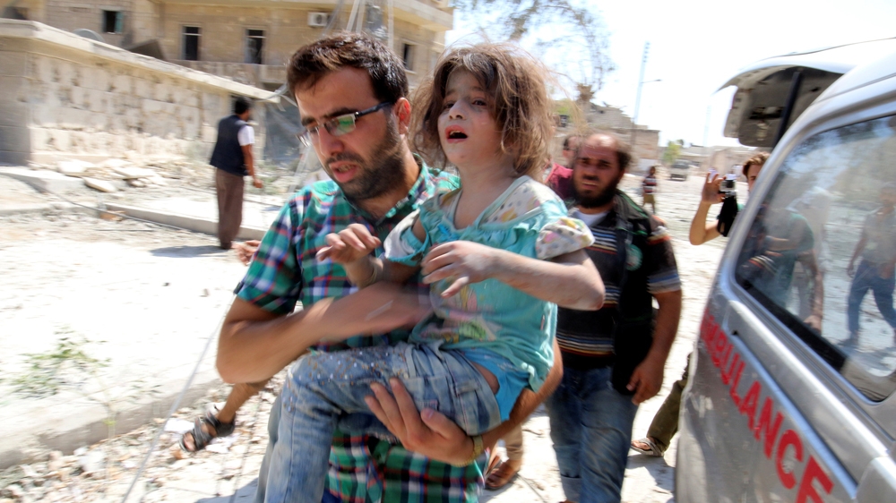 A man carries a girl that survived double air strikes on Saturday in a rebel-held neighbourhood of Aleppo 