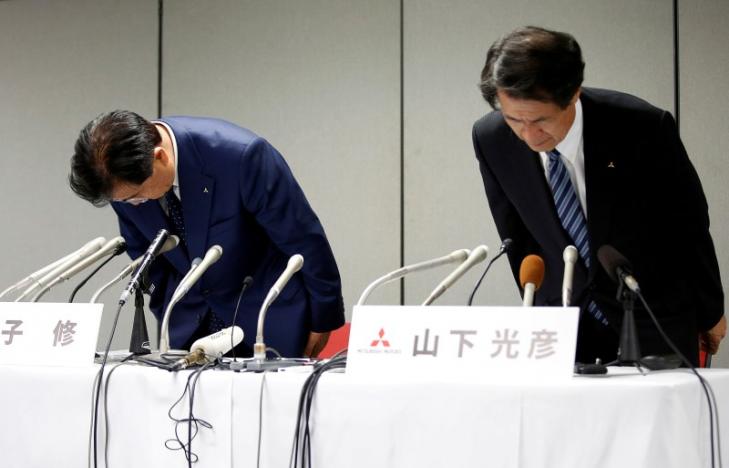 Mitsubishi Motors Corp's Chairman and Chief Executive Officer Osamu Masuko (L) and Head of Research and Development Mitsuhiko Yamashita bow their heads to apologize over the company's mileage scandal at a news conference in Tokyo, Japan 