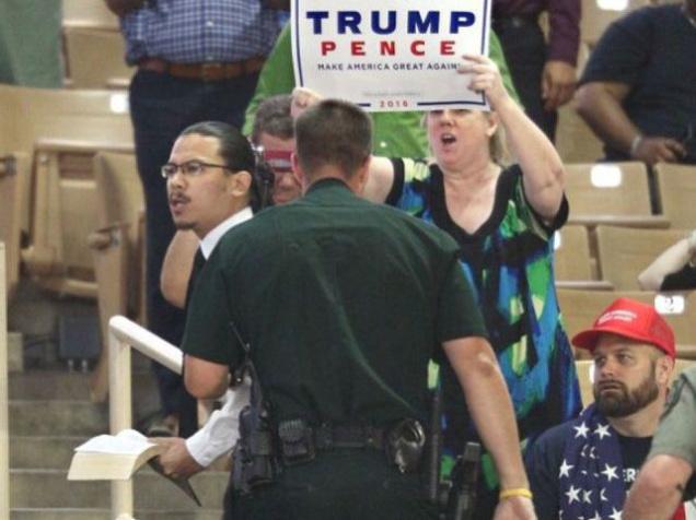 A protester holding and quoting from a Bible is hustled away by security after interrupting a campaign rally of Republican presidential candidate Donald Trump (not seen) at Silver Spurs Arena, inside the Osceola Heritage Park in Kissimmee, Florida on Thursday