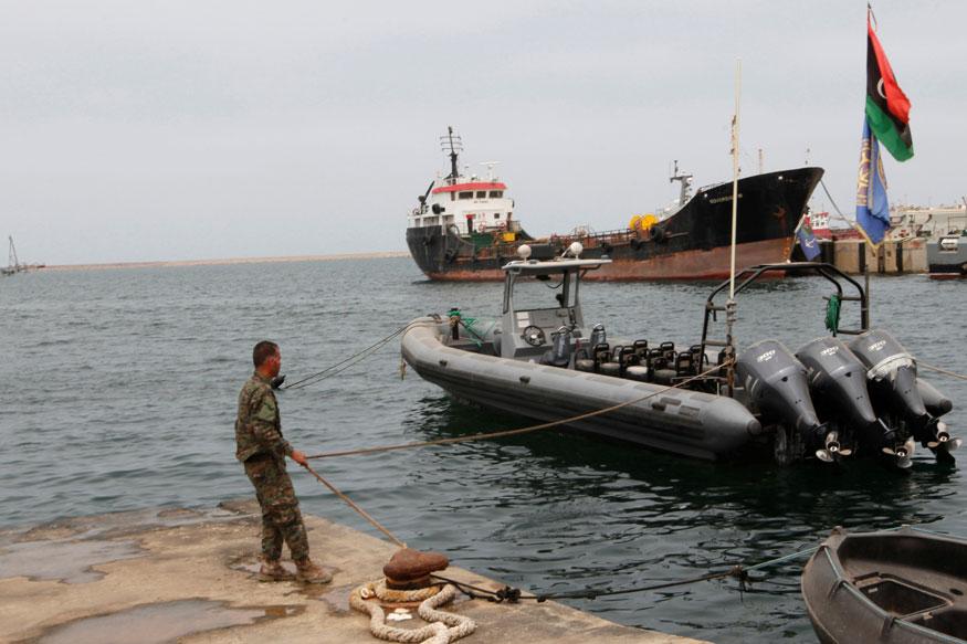 A member of the Libyan coast guard conducts a daily routine check on one of the patrol boats in Tripoli, Libya