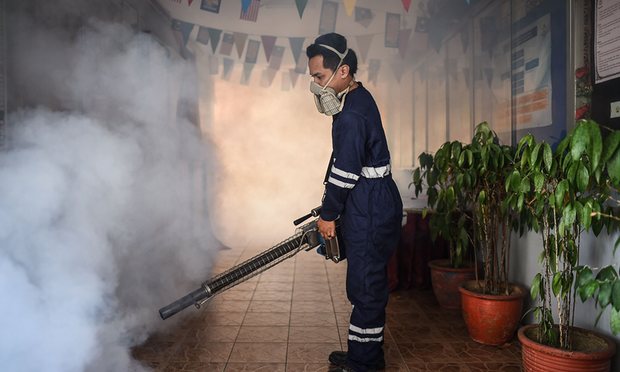 A pest control worker fumigates a school in Kuala Lumpur