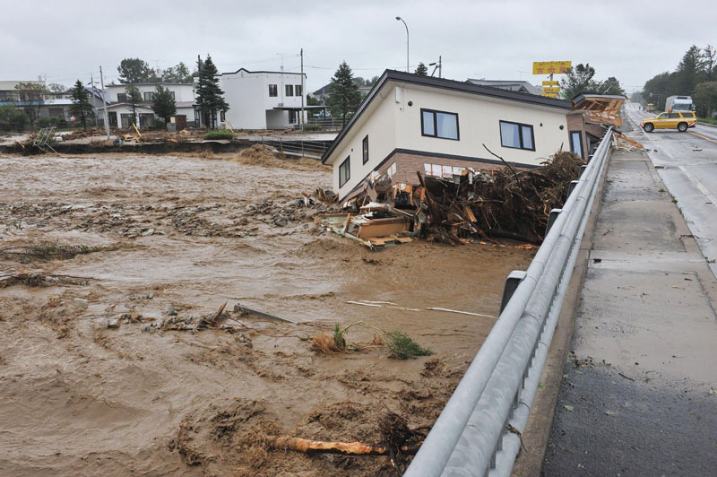 a house swept down a river at the town of Shimizu in Hokkaido prefecture, after Typhoon Lionrock struck overnight. Ten people were found dead in northern Japan
