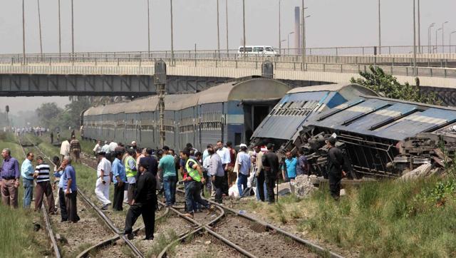 Egyptians check the wreckage of a train after it derailed near the village of Al-Ayyat in Giza