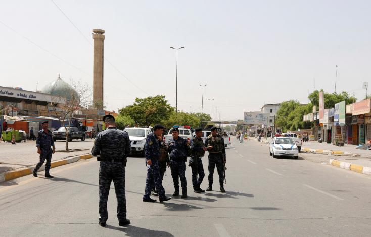 Iraqi security forces gather at the site of a suicide bomb blast in Baghdad al-Jadida, Iraq 