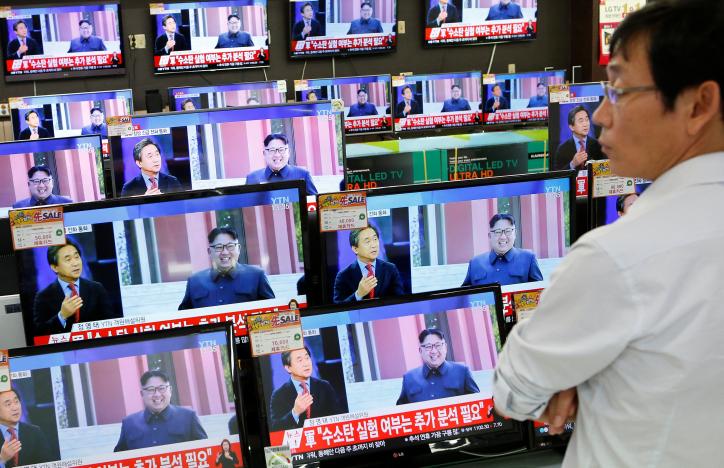 A sales assistant watches TV sets broadcasting a news report on North Korea's fifth nuclear test, in Seoul, South Korea