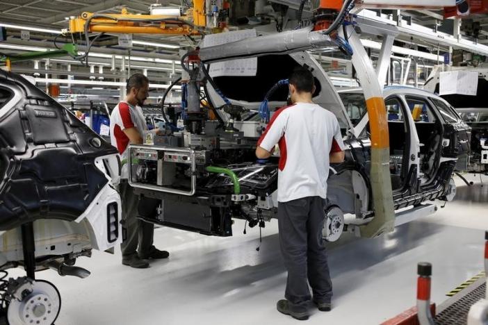 Workers from the SEAT factory, under the Volkswagen group, work on an engine of a SEAT Leon car, in Martorell near Barcelona 