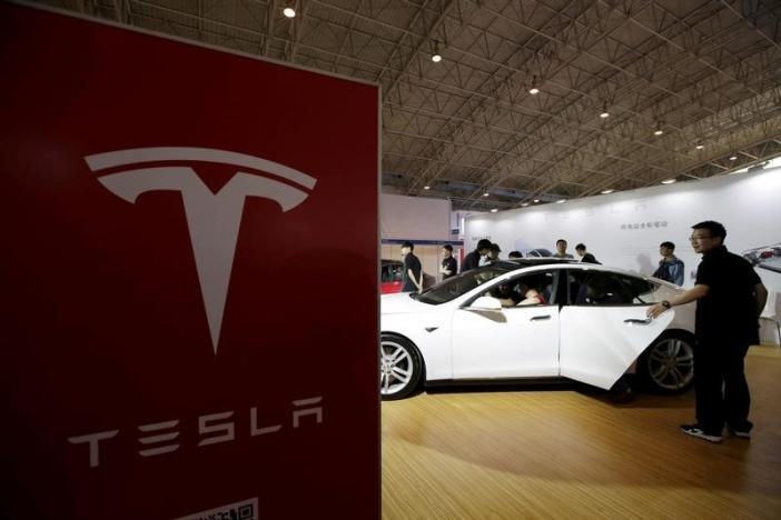 People view a Tesla car during the Auto China 2016 in Beijing, China