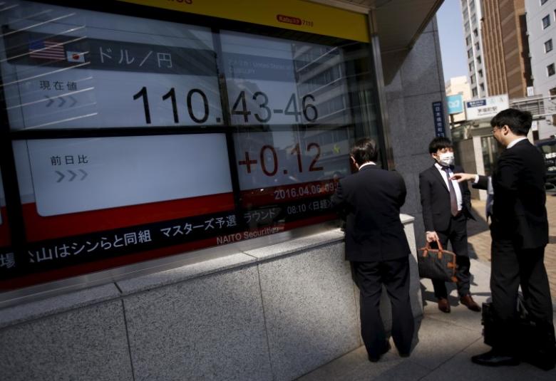 Businessmen stand in front of electronic boards showing the exchange rate between Japanese yen against the U.S. dollar outside a brokerage in Tokyo, Japan 