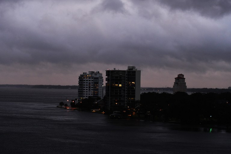 Dark clouds hover over apartment buildings on the bank of a river in Jacksonville, Florida