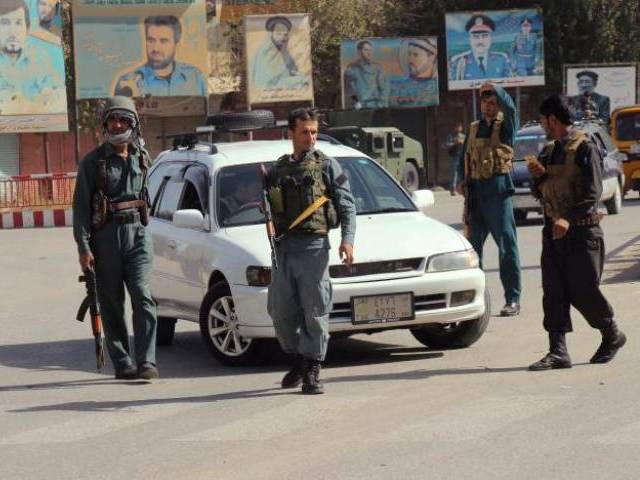 Afghan policemen keep watch in the downtown of Kunduz city, Afghanistan