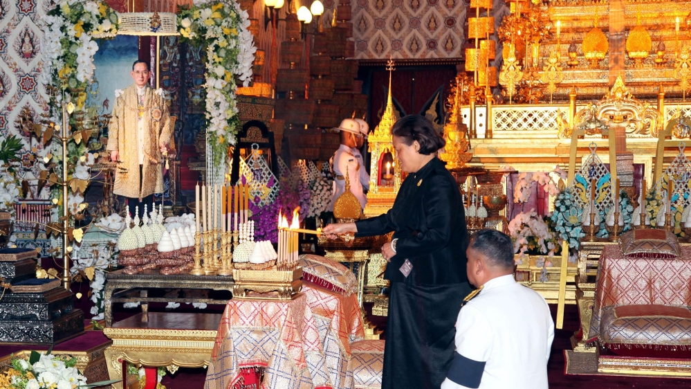 Thai Princess Maha Chakri Sirindhorn lights candles next to portrait of late Thai King Bhumibol on Saturday