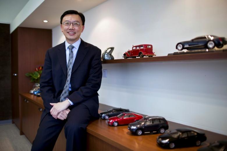 Matthew (Matt) Tsien, president of General Motors (GM) China, poses for a photograph next to GM car scale models in his office at the company's headquarters in Shanghai, China