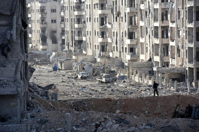 A person stands amid heavily damaged buildings in Aleppo's 1070 district on November 8, 2016