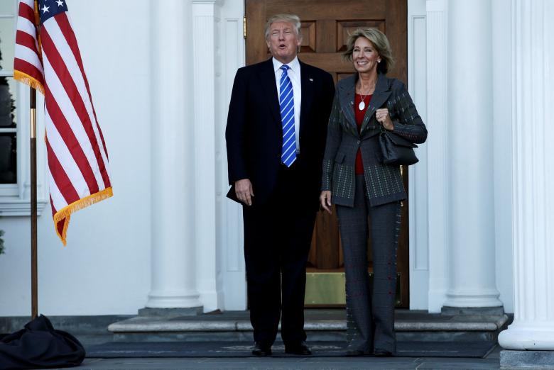 U.S. President-elect Donald Trump (L) stands with Betsy DeVos after their meeting at the main clubhouse at Trump National Golf Club in Bedminster, New Jersey, U.S., 