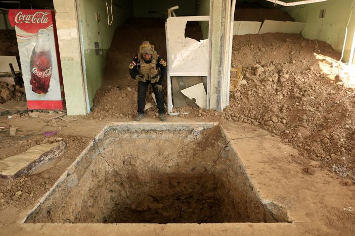 An Iraqi special forces soldier looks inside the entrance of a tunnel used by Islamic State militants inside a restaurant in Bazwaia, east of Mosul, Iraq