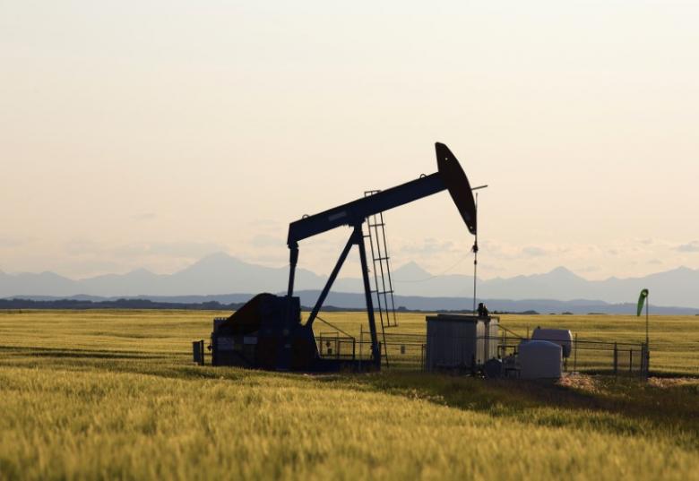 An oil pump jack pumps oil in a field near Calgary, Alberta